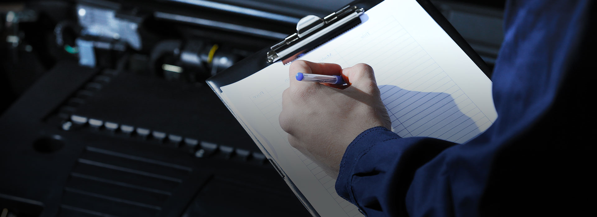 Mechanic writting on a clipboard during MOT test