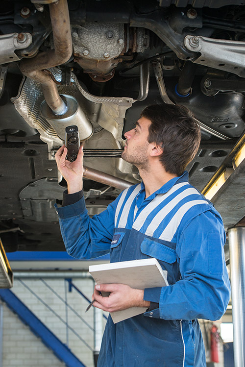 Mechanic working under car on a ramp