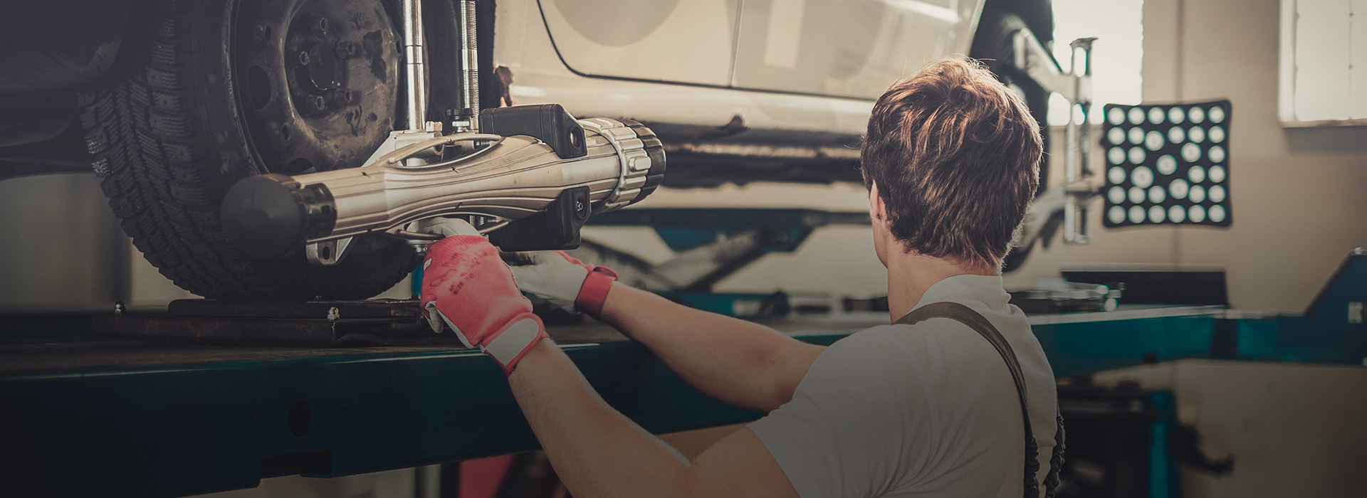 Mechanic performing wheel alignment on a car